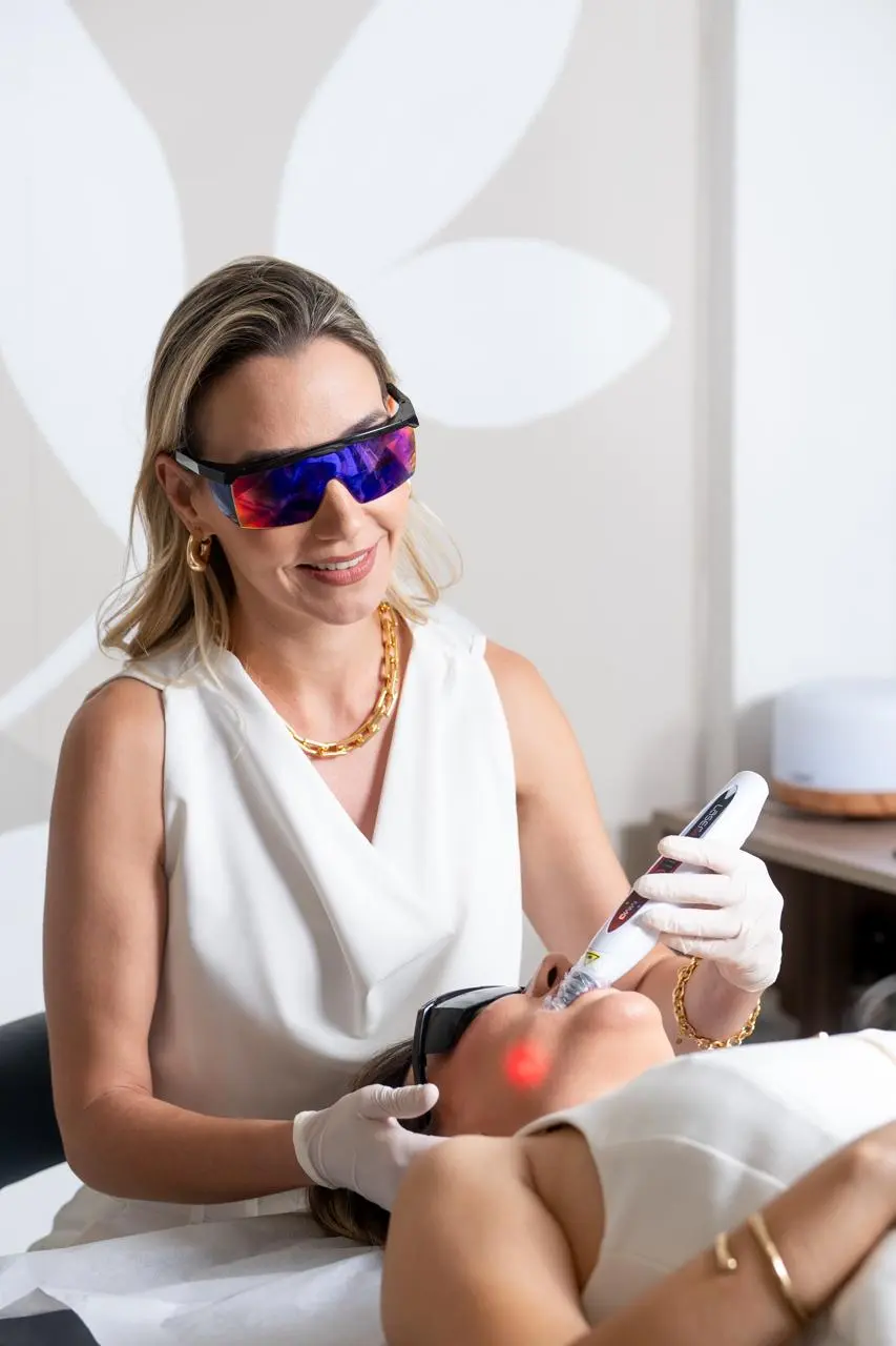 Fisioterapeuta aplicando laserterapia na região facial do paciente